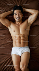 Smiling muscular man relaxing on brown bed linens