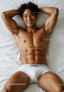 Smiling man relaxing on bed in white underwear