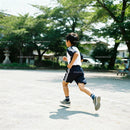 Young boy running energetically on a sunny outdoor track