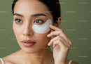 Young Woman with Brown Eyes Applying Skincare Patch Close-Up Photo