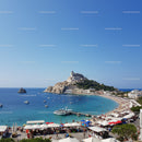 Scenic Coastal Town with Castle Overlooking a Vibrant Beach Scene