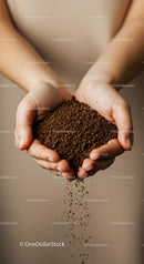 Hands gently holding and pouring coffee granules