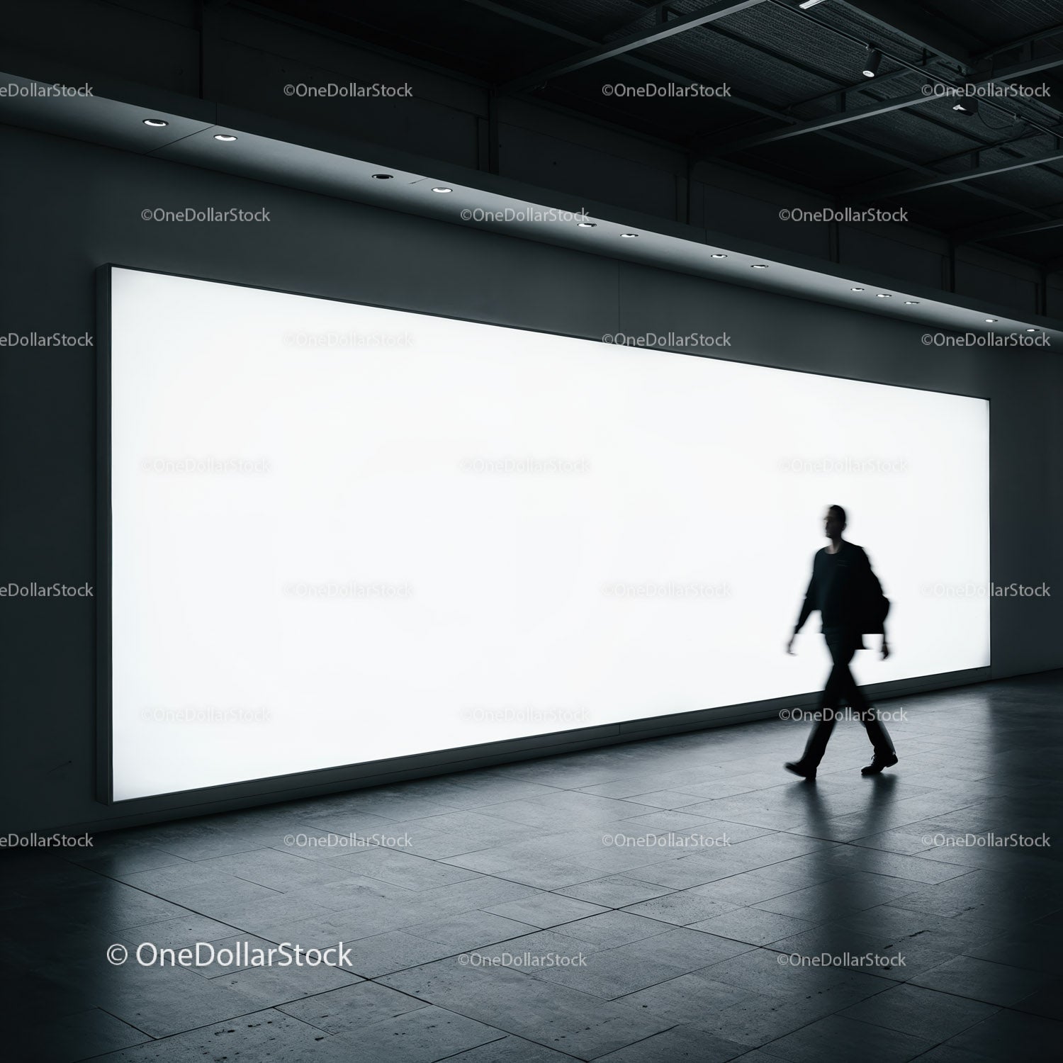 Sylwetka mężczyzny przechodzącego obok jasnego billboardu w nowoczesnej przestrzeni