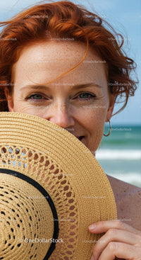 Bright Smiling Woman with Freckles Holding Straw Hat on Sunny Beach