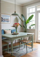 Cozy Sunlit Dining Area with Green Houseplant and Colorful Flowers
