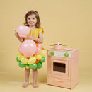 Little girl in balloon skirt holding giant pink cup
