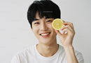 Young Man Smiling with Lemon Slice in Hand Bright Natural Portrait