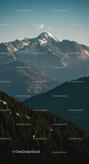 Majestic Snow-Covered Mountain Peak with Forested Hills