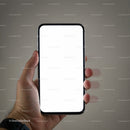 Hand holding smartphone with blank white screen