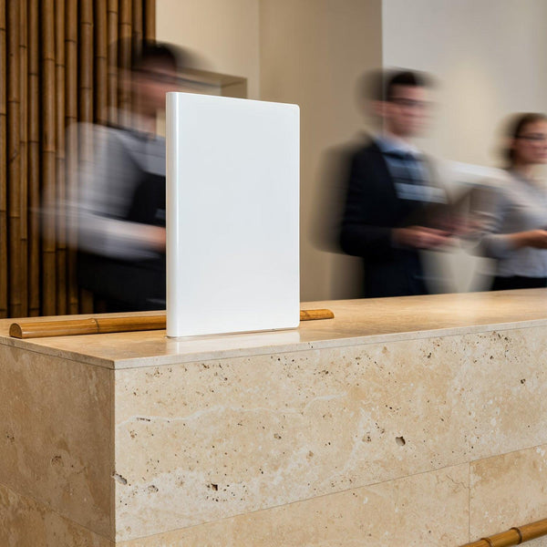 Blank white menu on polished stone counter in busy lobby JPG Mockup Image
