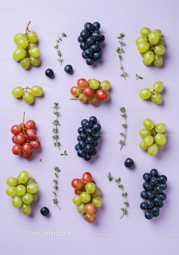 Variety of fresh grapes and thyme sprigs on pastel surface