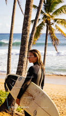 Woman Surfer Standing on Tropical Beach Holding Surfboard