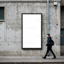 Man walking past blank urban advertising billboard