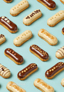 Assorted Eclairs with Chocolate and Cream Toppings on Blue