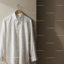 White button-up shirt hanging on wooden hanger