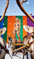 Smiling woman in bikini posing with reindeer sled in snow