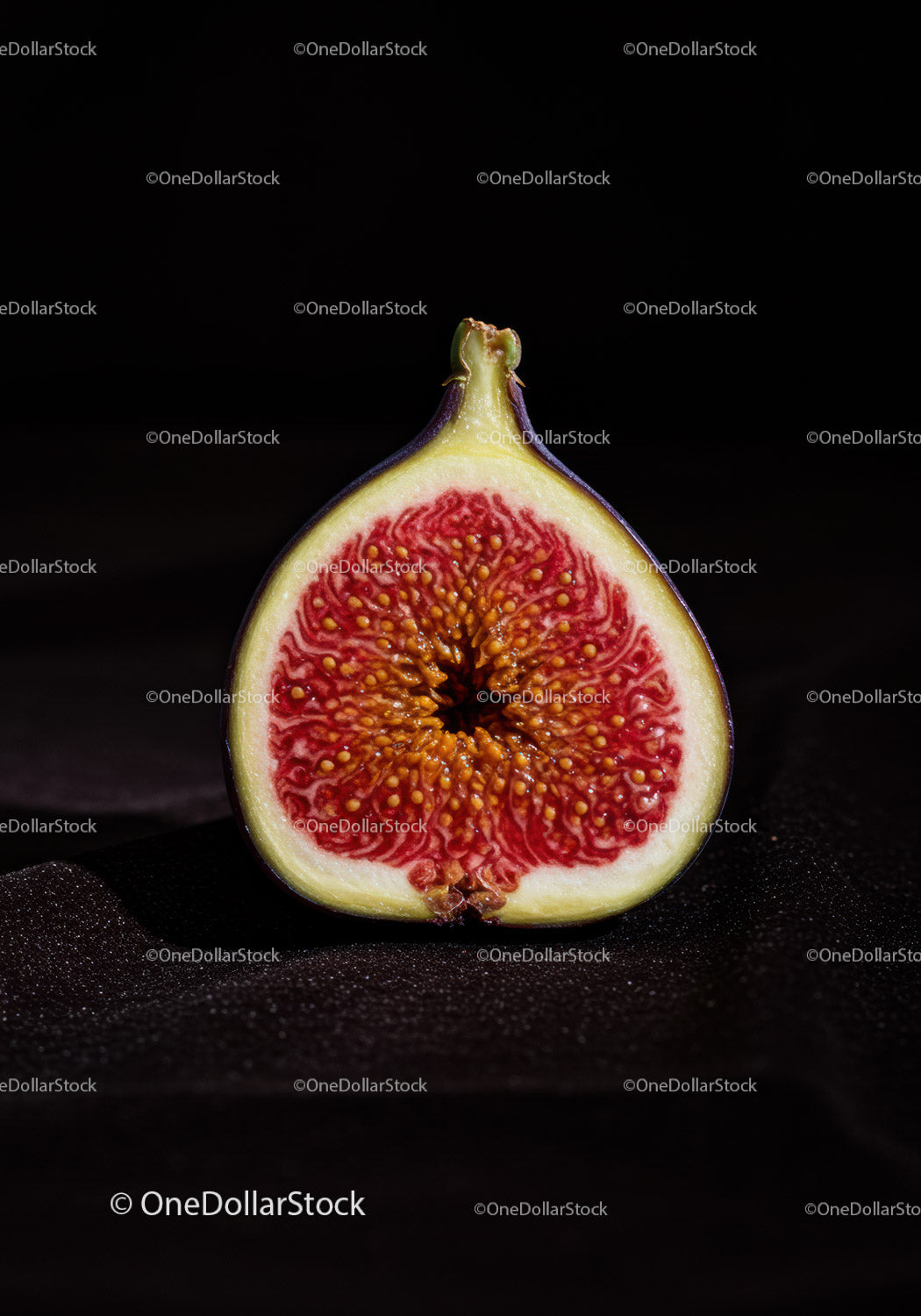 Fresh ripe fig cut in half on dark background