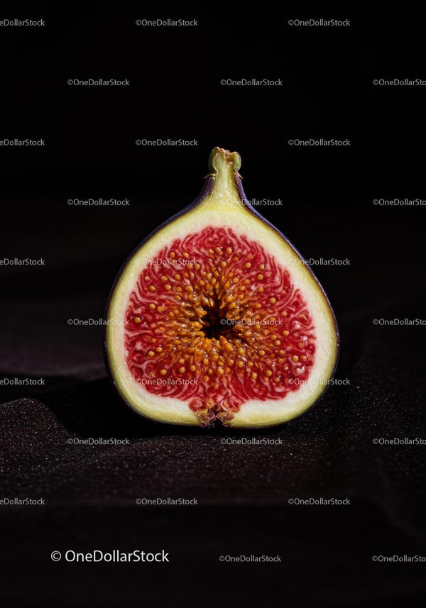 Fresh ripe fig cut in half on dark background