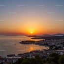 Beautiful Sunset Over Orange and Pink Sky with Coastal Town and Boats