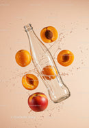 Clear glass bottle with ripe apricots splashing water