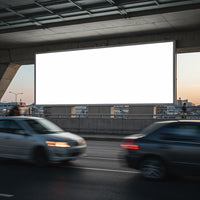 Blank billboard above busy urban road at dusk