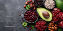 Assorted Fresh Fruits and Nuts with Avocado and Berries on Dark Surface