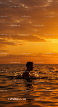 Serene Man Swimming in Ocean During Vibrant Sunset