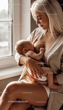 Mother breastfeeding her baby by a sunlit window