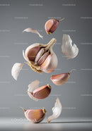 Close up of garlic cloves and peeled skin in midair