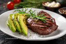Grilled Steak with Avocado Slices and Fresh Rosemary on White Plate