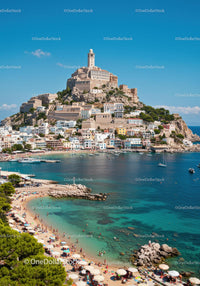 Scenic Coastal Town with Fortress and Beach Under Bright Blue Sky