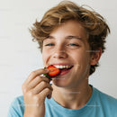 Young Boy Enjoying Fresh Strawberries Smiling Outdoors