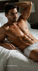 Fit young man relaxing on bed in white underwear