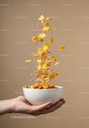 Hand Holding Bowl with Flying Cornflakes Against Brown Wall