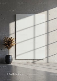 Minimalist room with blank canvas and potted dried plant