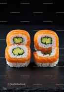 Fresh salmon sushi rolls with avocado on black slate