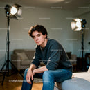 Young man in casual clothes sitting indoors thoughtfully