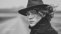 Black and White Portrait of a Young Man with Curly Hair Wearing Fedora