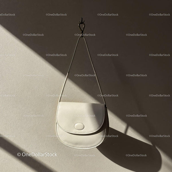 Minimalist white leather bag hanging on wall JPG Mockup Image
