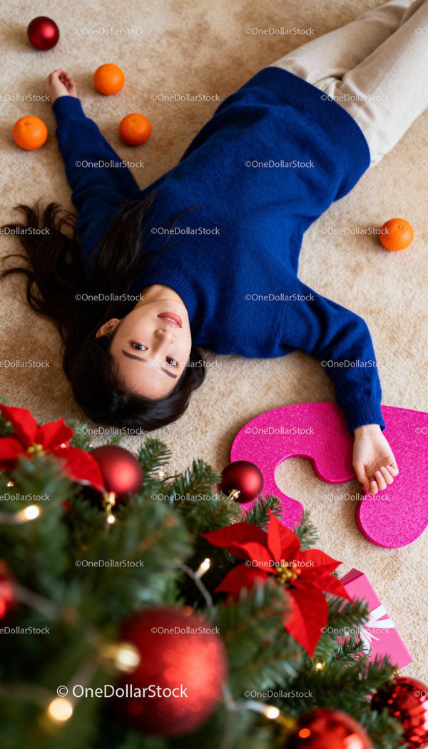 Relaxed woman lying near decorated Christmas tree with oranges