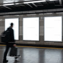 Blurred man walking past empty advertising panels
