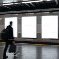 Blurred man walking past empty advertising panels