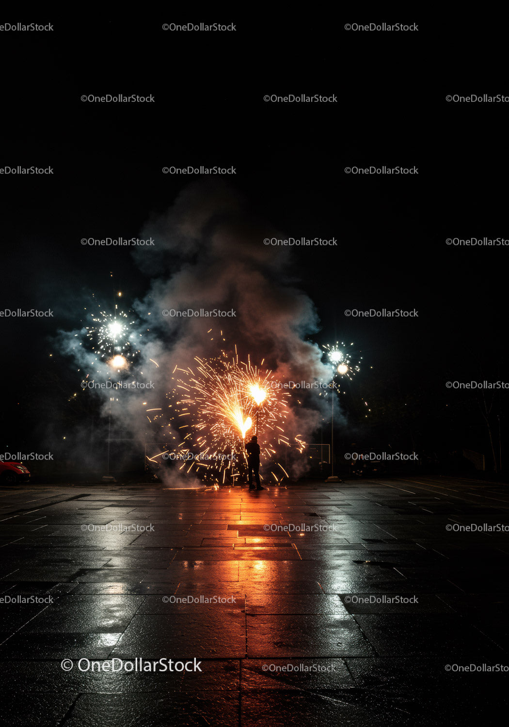 Person Enjoying Fireworks Display on Wet Pavement at Night