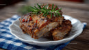 Juicy Grilled Pork Ribs with Rosemary Garnish on Rustic Plate