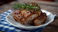 Juicy Grilled Pork Ribs with Rosemary Garnish on Rustic Plate
