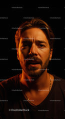 Thoughtful man illuminated by warm soft light in dark