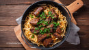 Beef Stroganoff with Pasta Garnished with Fresh Herbs on Rustic Table
