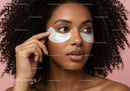 Elegant Woman with Curly Hair Applying Under-Eye Patches for Skincare