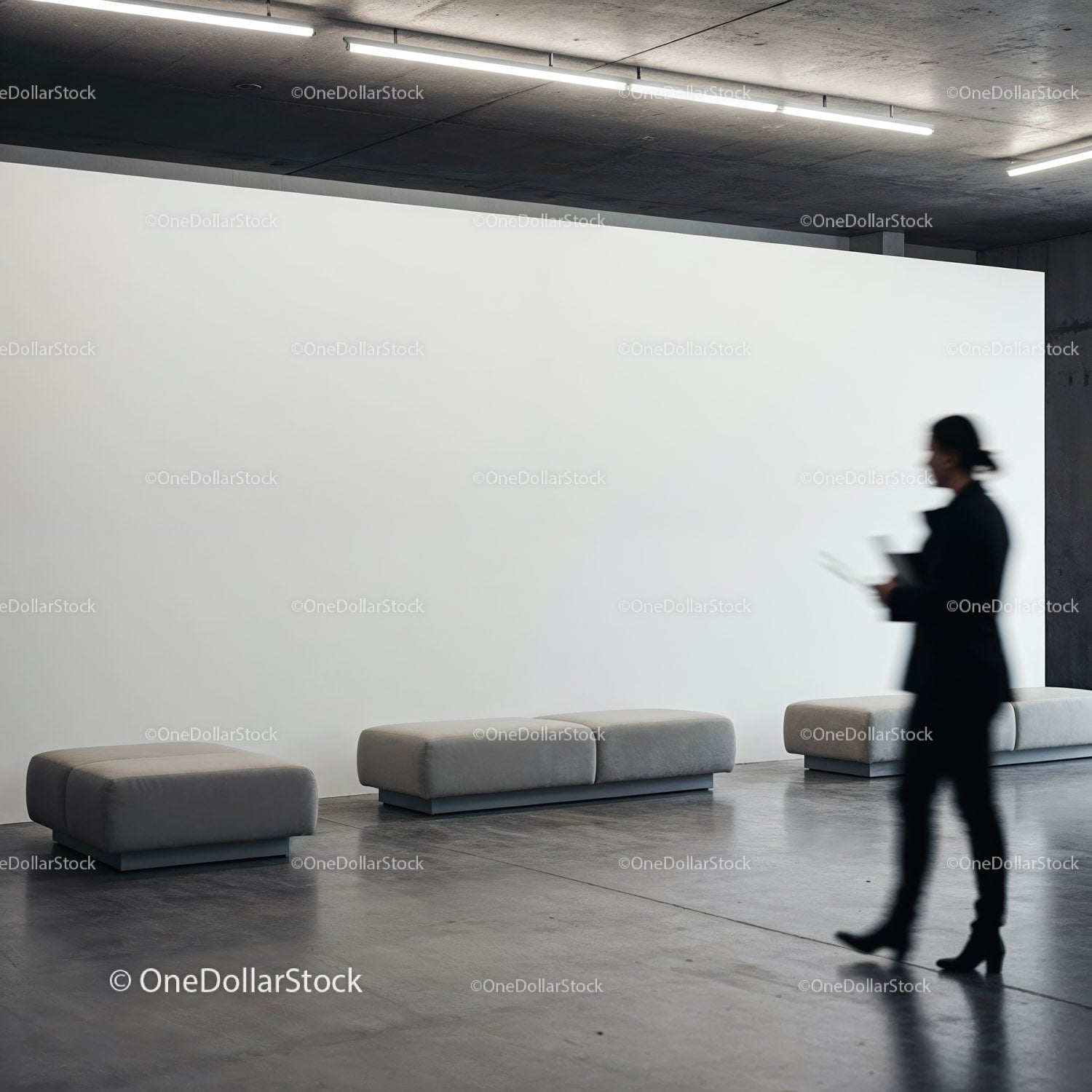 Blurred businesswoman walking past modern gray benches