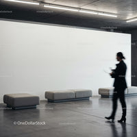 Blurred businesswoman walking past modern gray benches